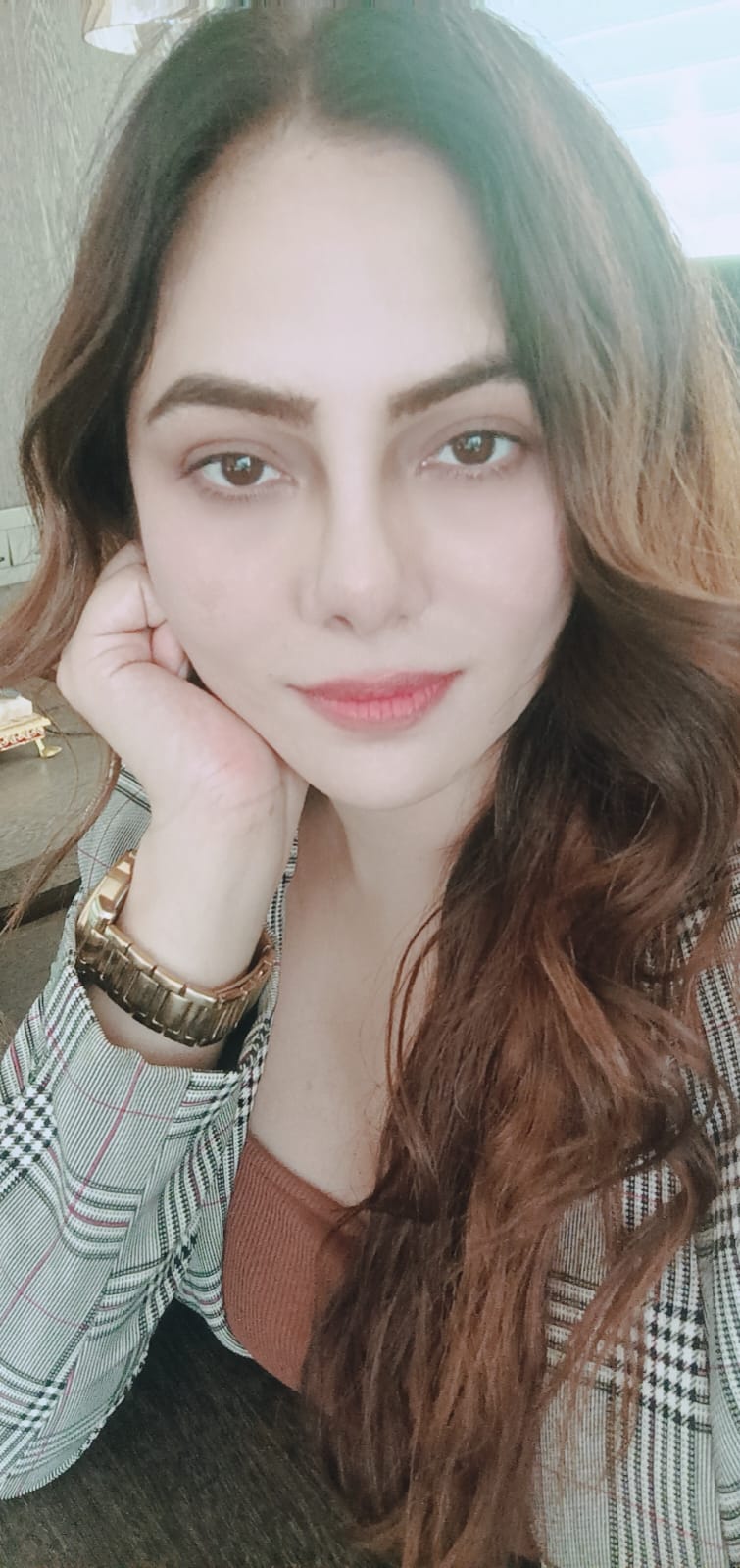 Portrait of Vibha Jain, hypnotherapist, resting her chin on her hand and looking towards the camera.