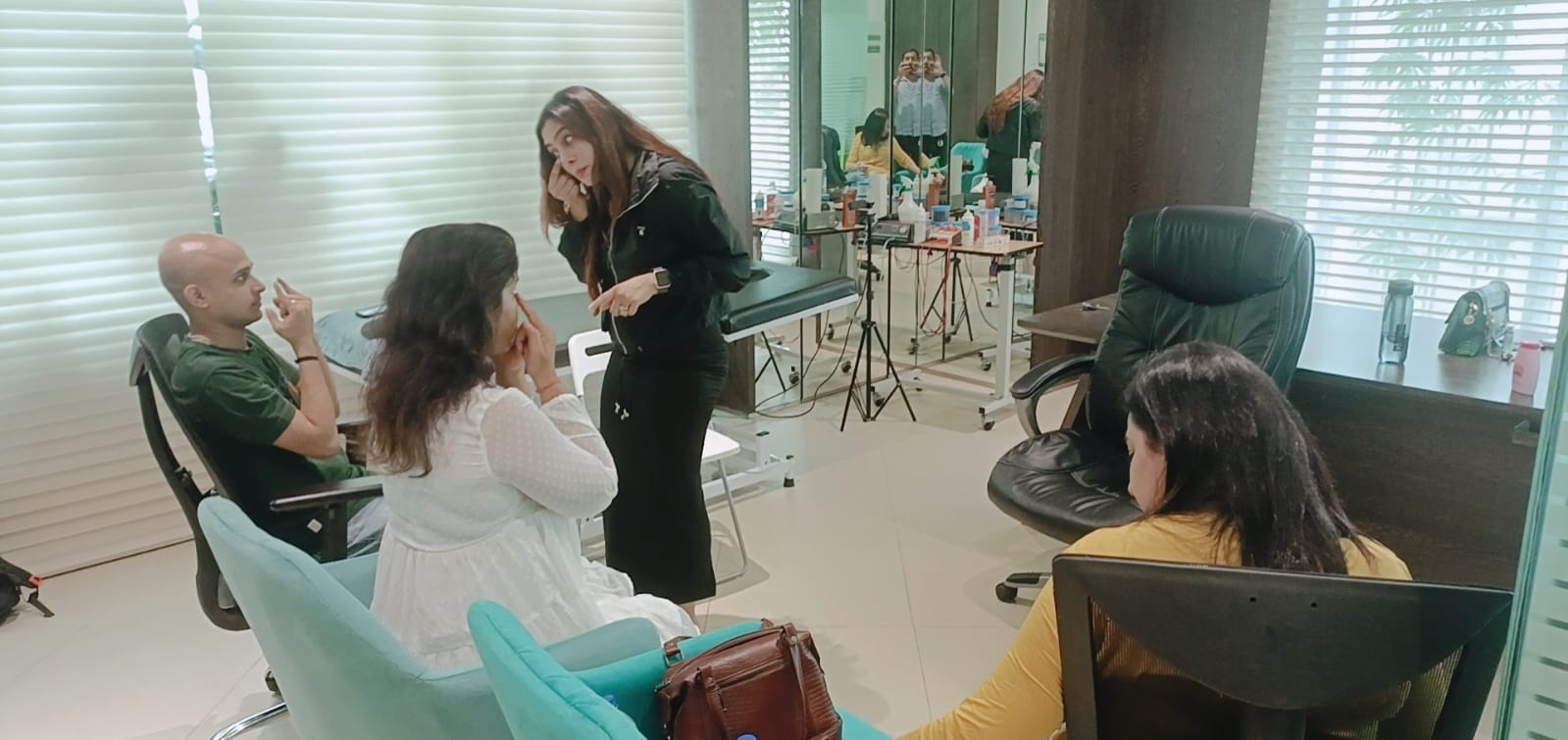 Vibha Jain in conversation with several people seated in a practice room, discussing an exercise.